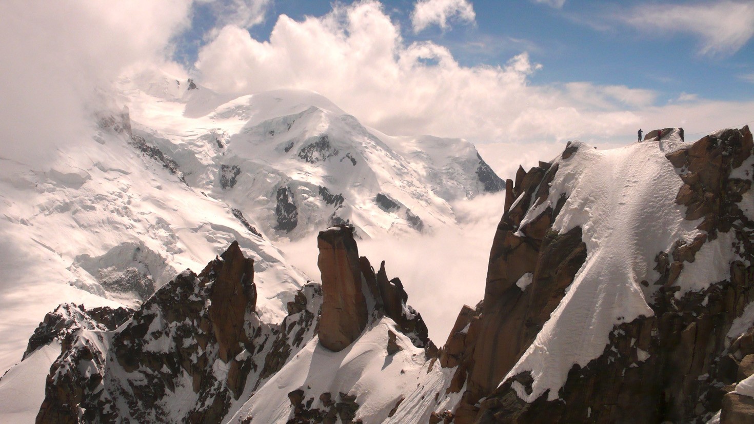 Mont Blanc and climbers on the Arête des Cosmiques, seen from the Aiguille du Midi